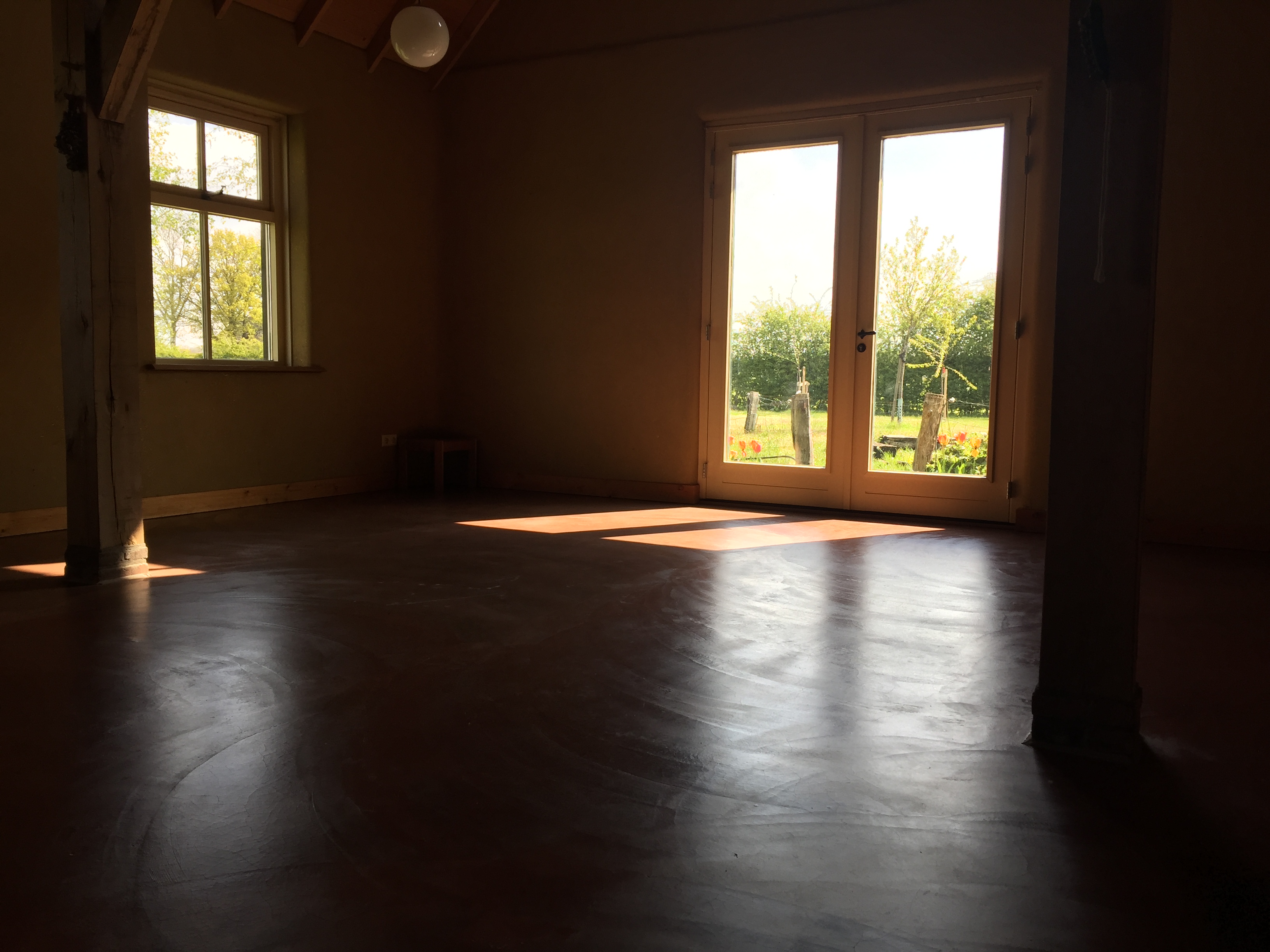 Stukje grote zaal, met openslaande deuren naar de vuurplaats.